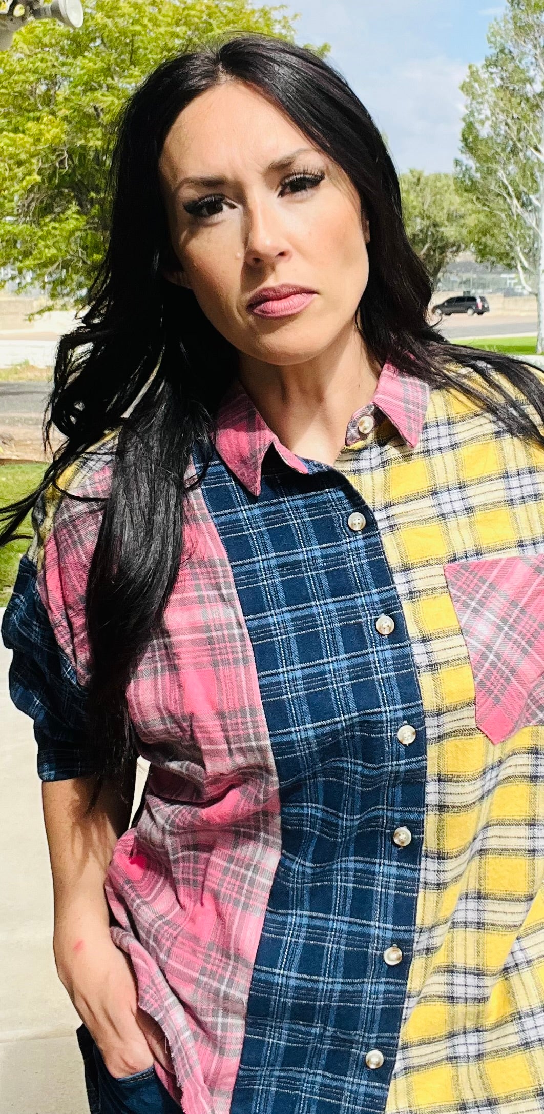 Woman wearing a colorful plaid shirt with a checkered pattern.