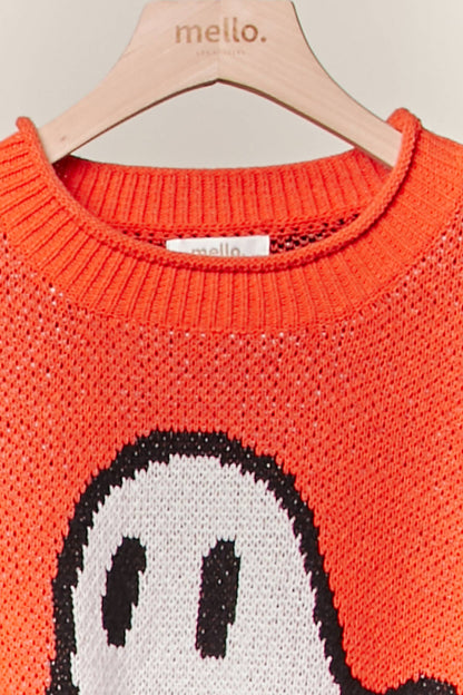 Orange sweater with ghost design on a hanger