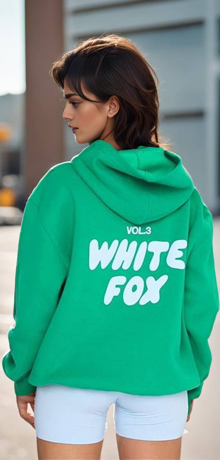 Person wearing a green hoodie with 'White Fox' text, standing outdoors.