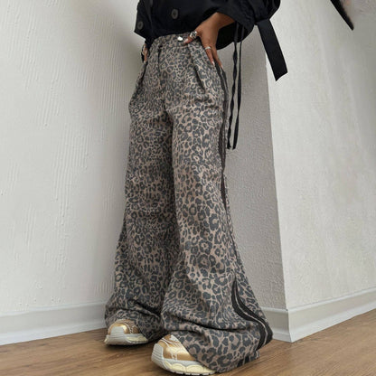 Person wearing leopard print pants against a plain wall.