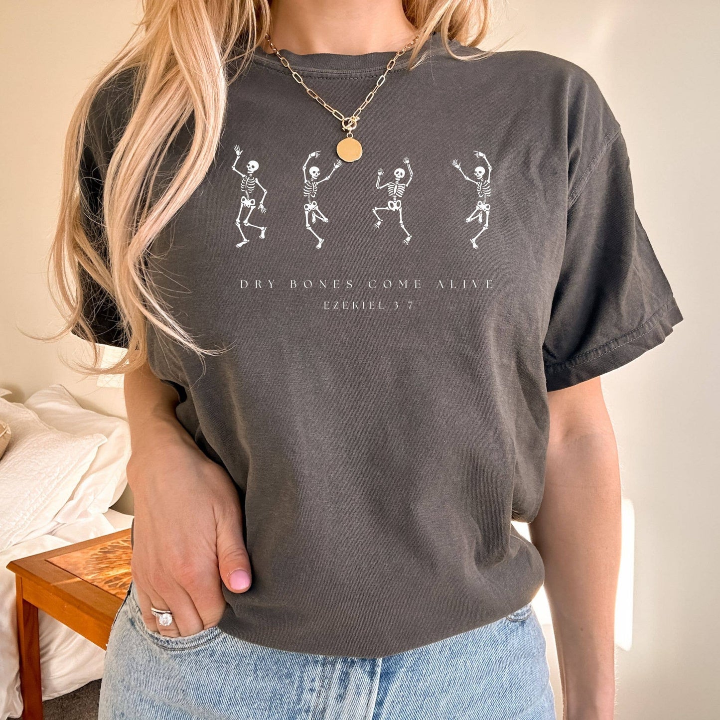 Person wearing a dark gray t-shirt with skeleton graphics and text.