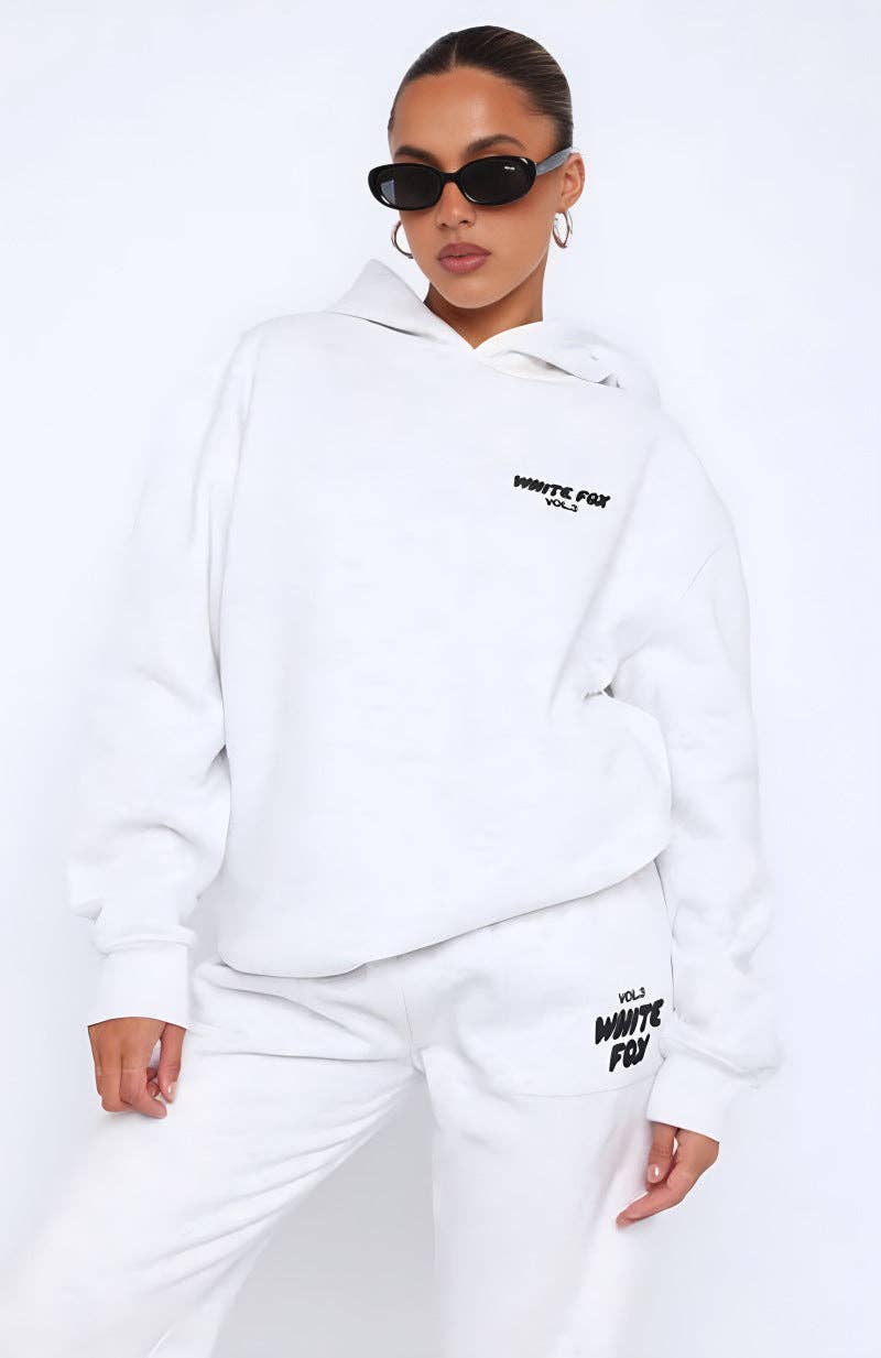 Person wearing a white hoodie and pants with text on a white background