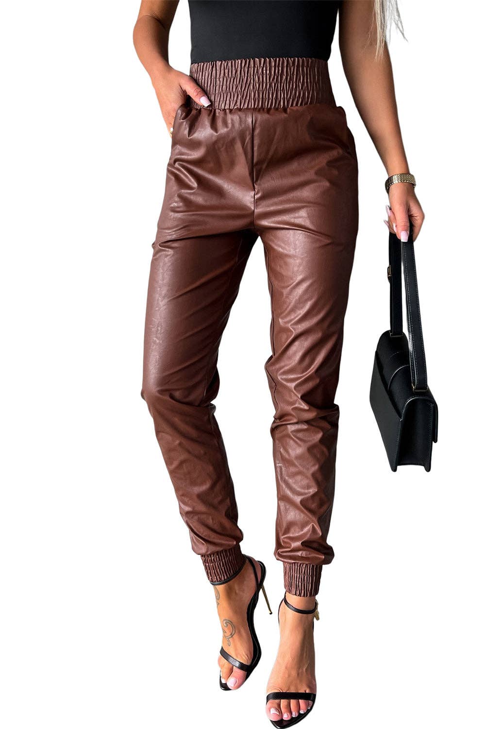 Brown leather jogger pants worn by a person on a white background