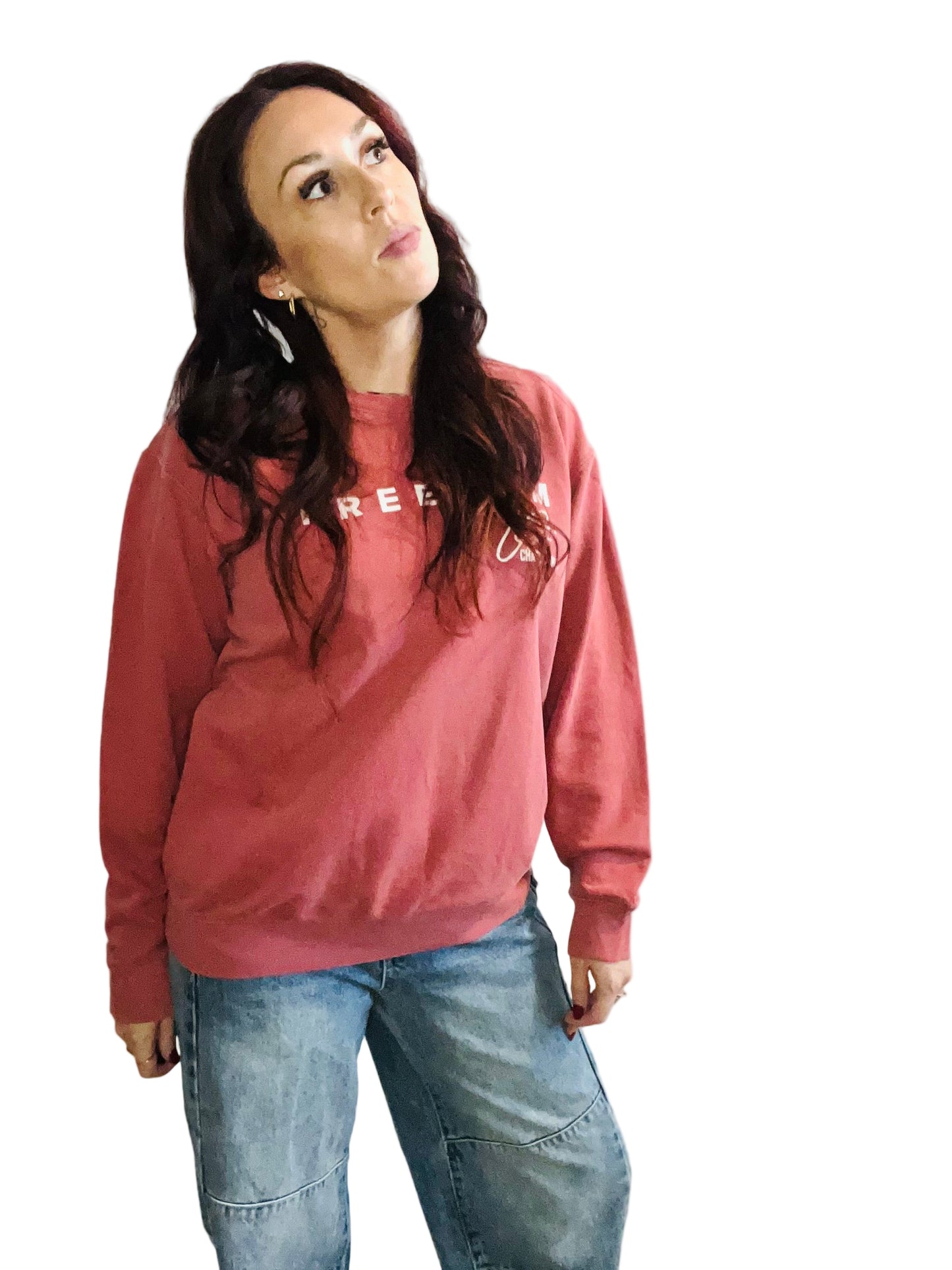 woman in crimson sweater and jeans in front off white background