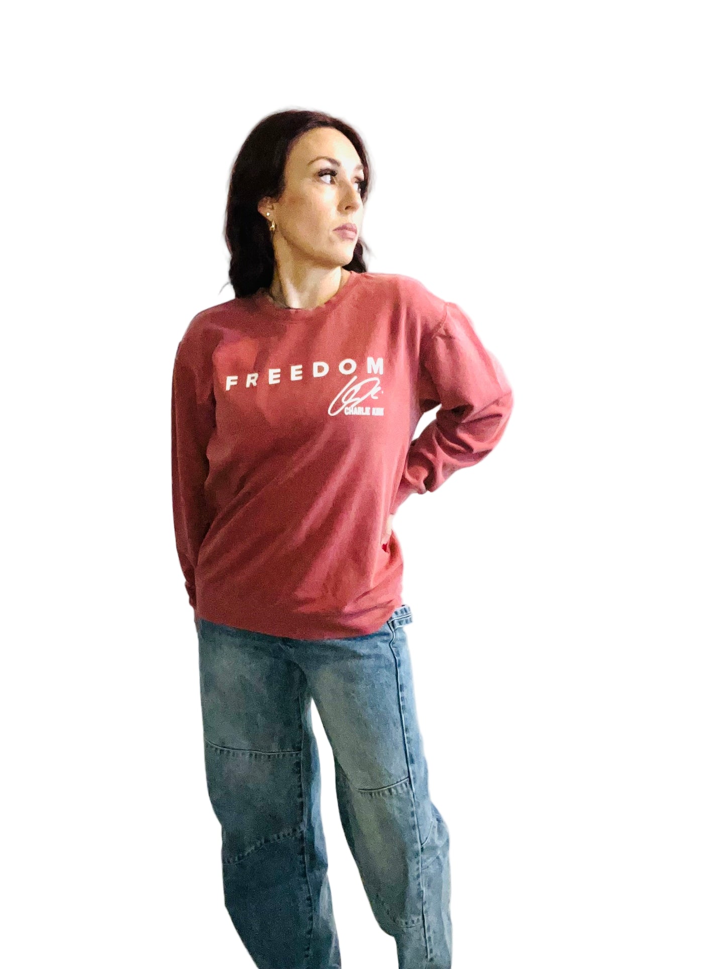 woman in crimson sweater and jeans in front off white background