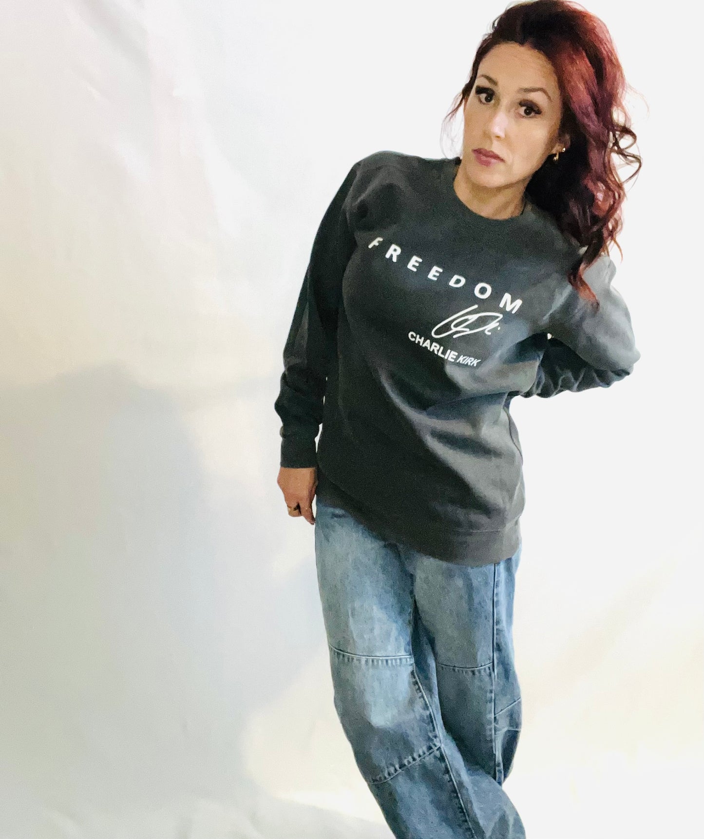 freedom sweater on woman in jeans infront of white background