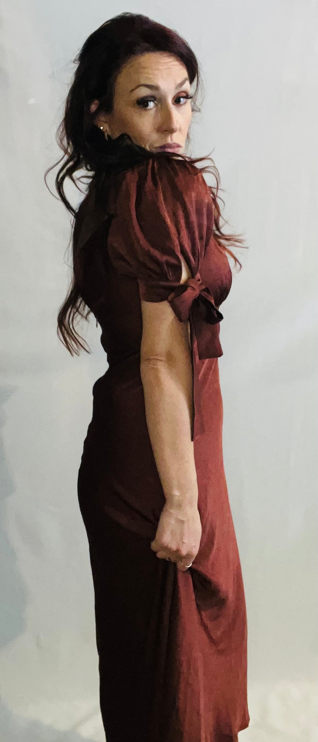 Woman wearing a brown dress against a white background
