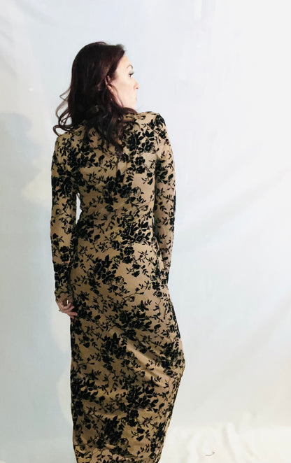 Woman wearing a long, floral-patterned dress against a white background