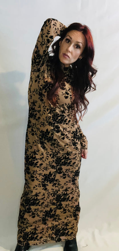 Woman wearing a long, floral-patterned dress against a white background