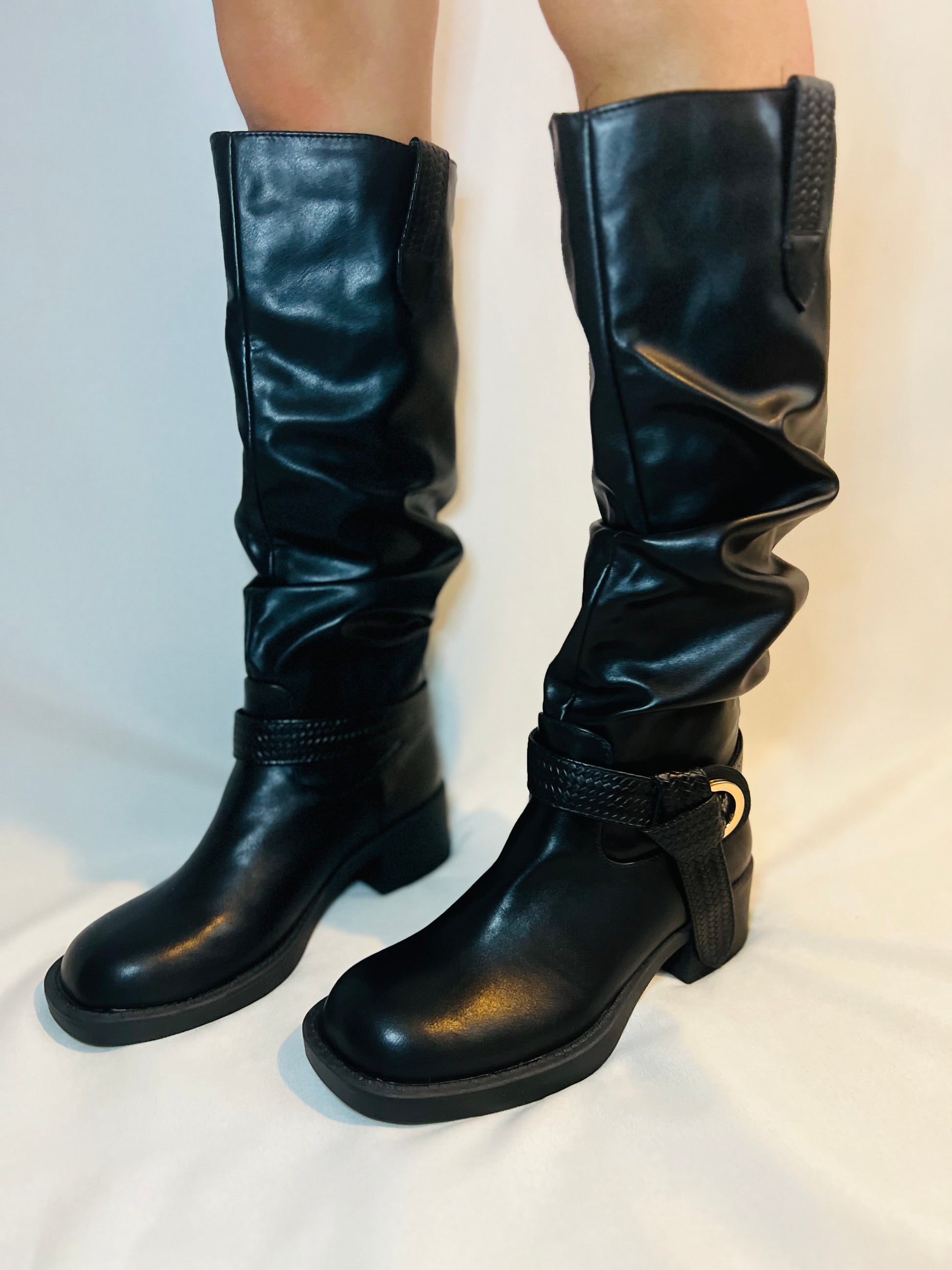 Black leather knee-high boots on a white background