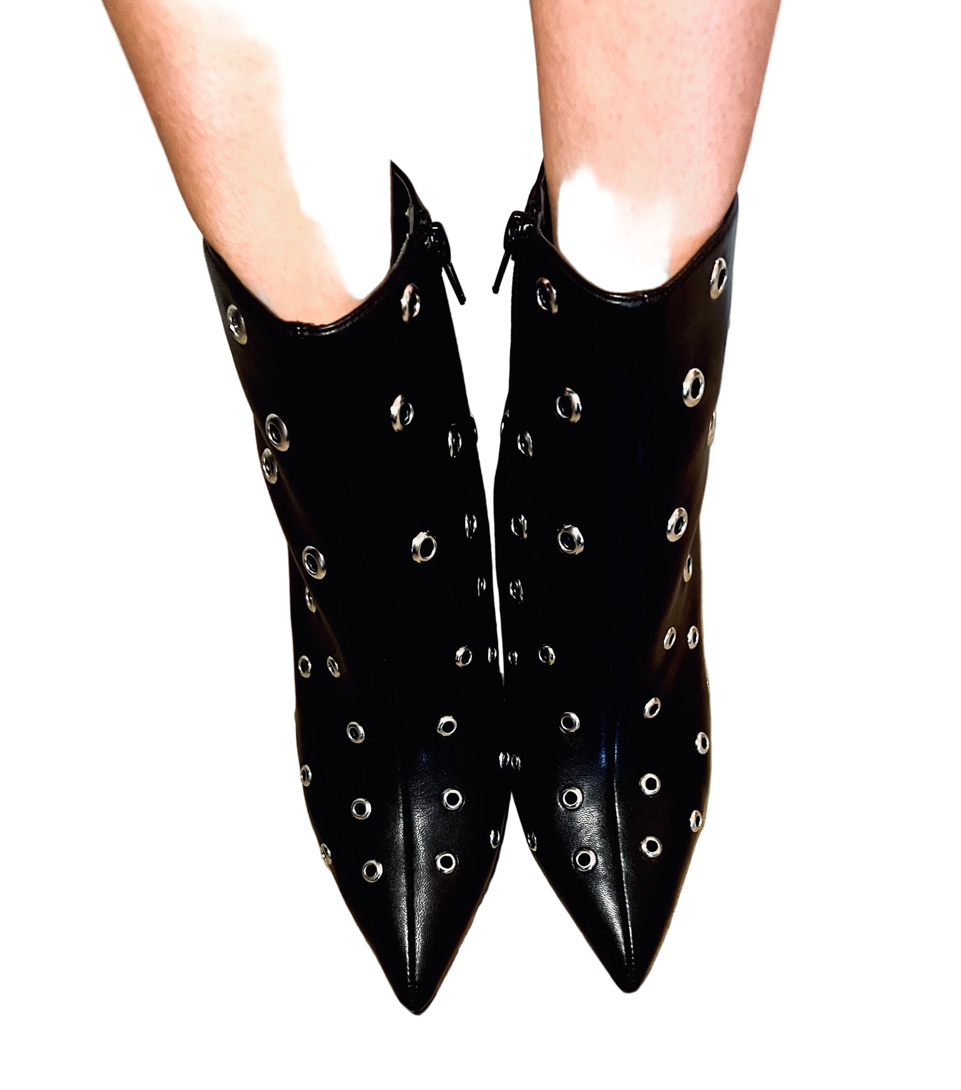 Black studded ankle boots on a wooden floor