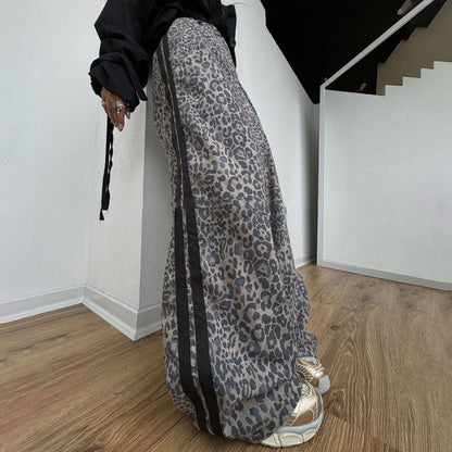 Person wearing leopard print pants and black top in a minimal indoor setting