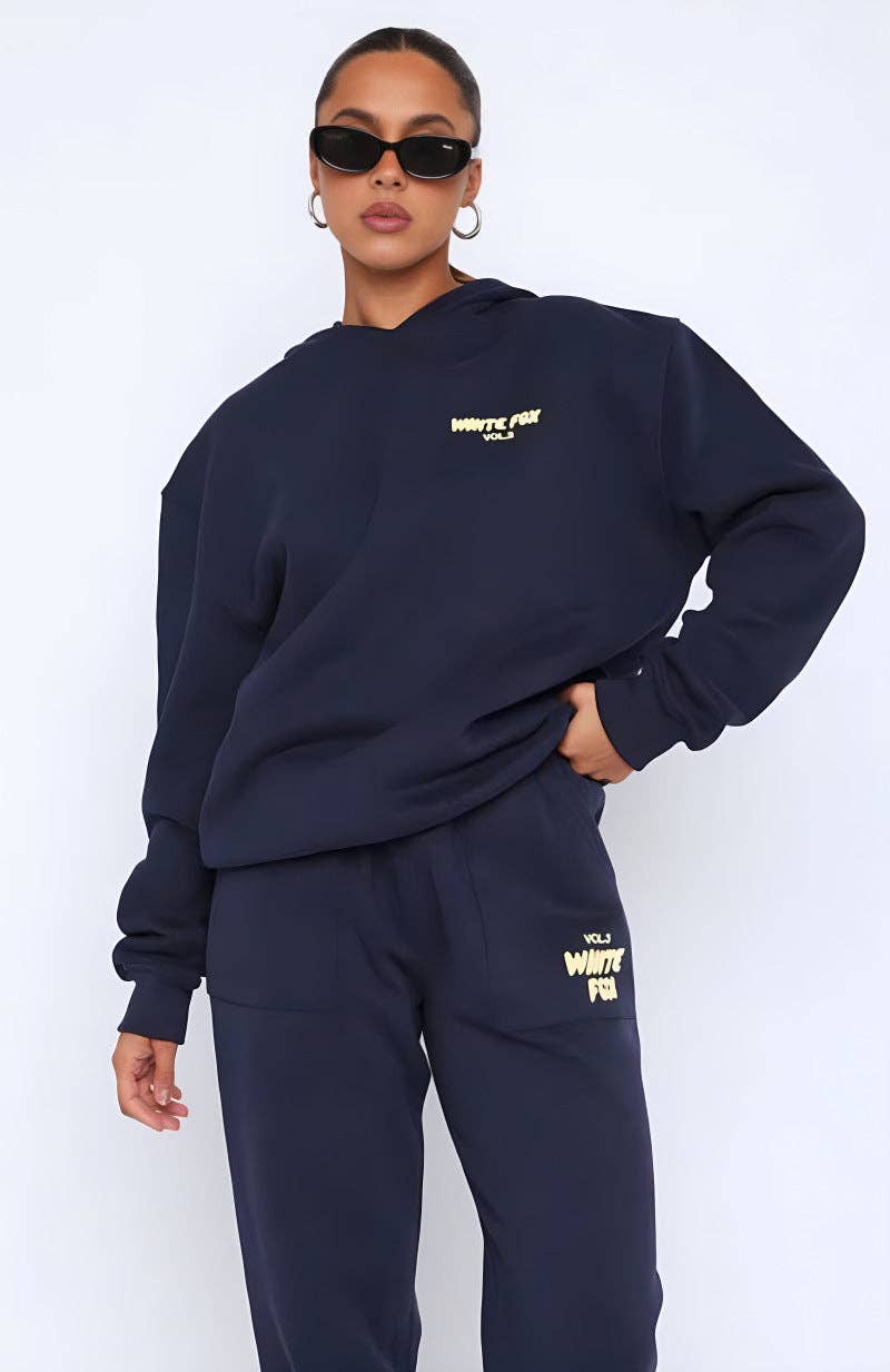 Person wearing a navy tracksuit with 'White Fox' branding on a white background