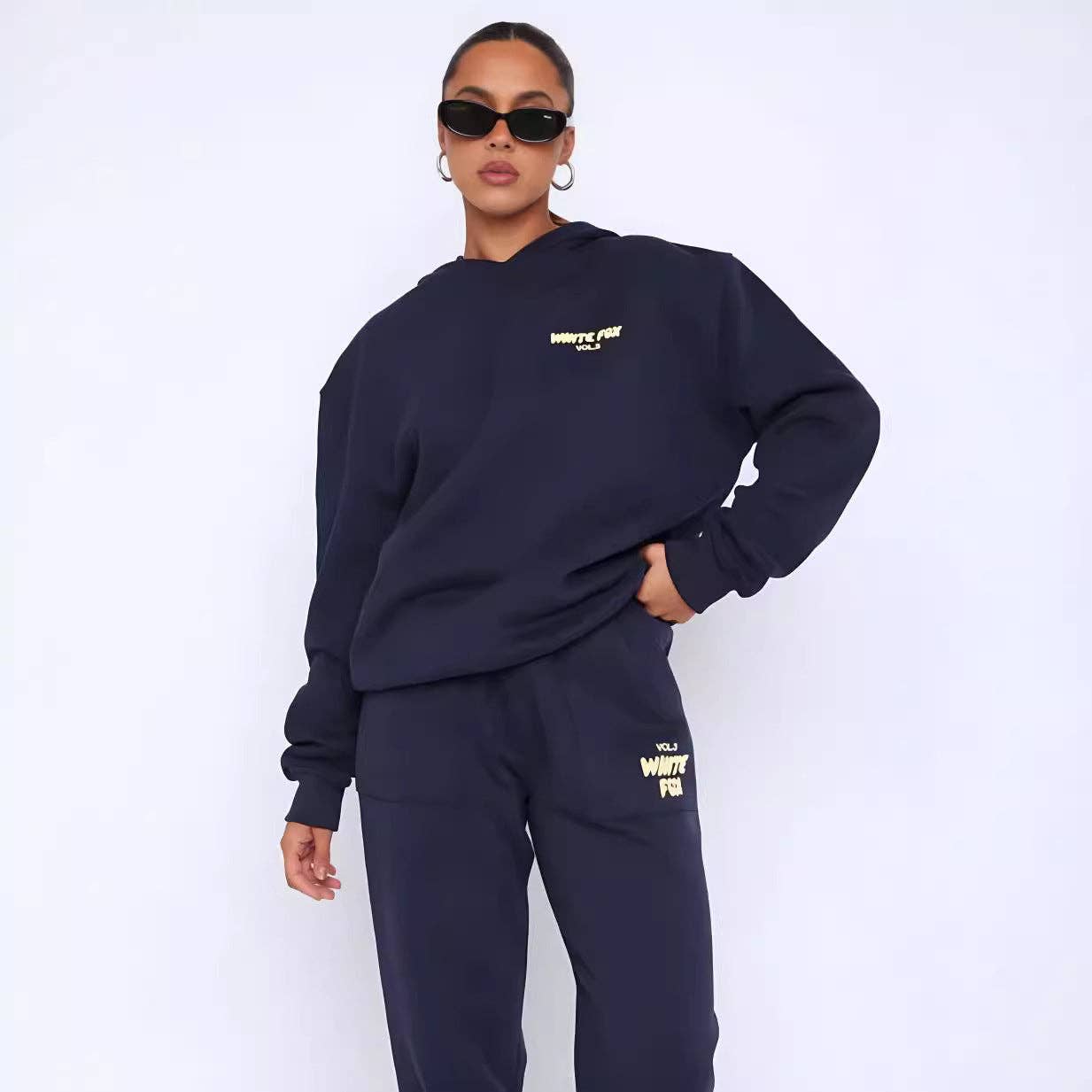 Person wearing a navy blue sweatshirt and pants with 'White Fox' branding on a white background