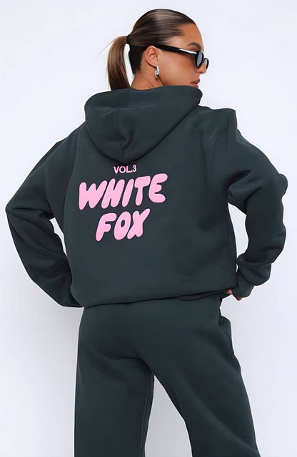 Person wearing a black hoodie with 'White Fox' text on the back against a white background