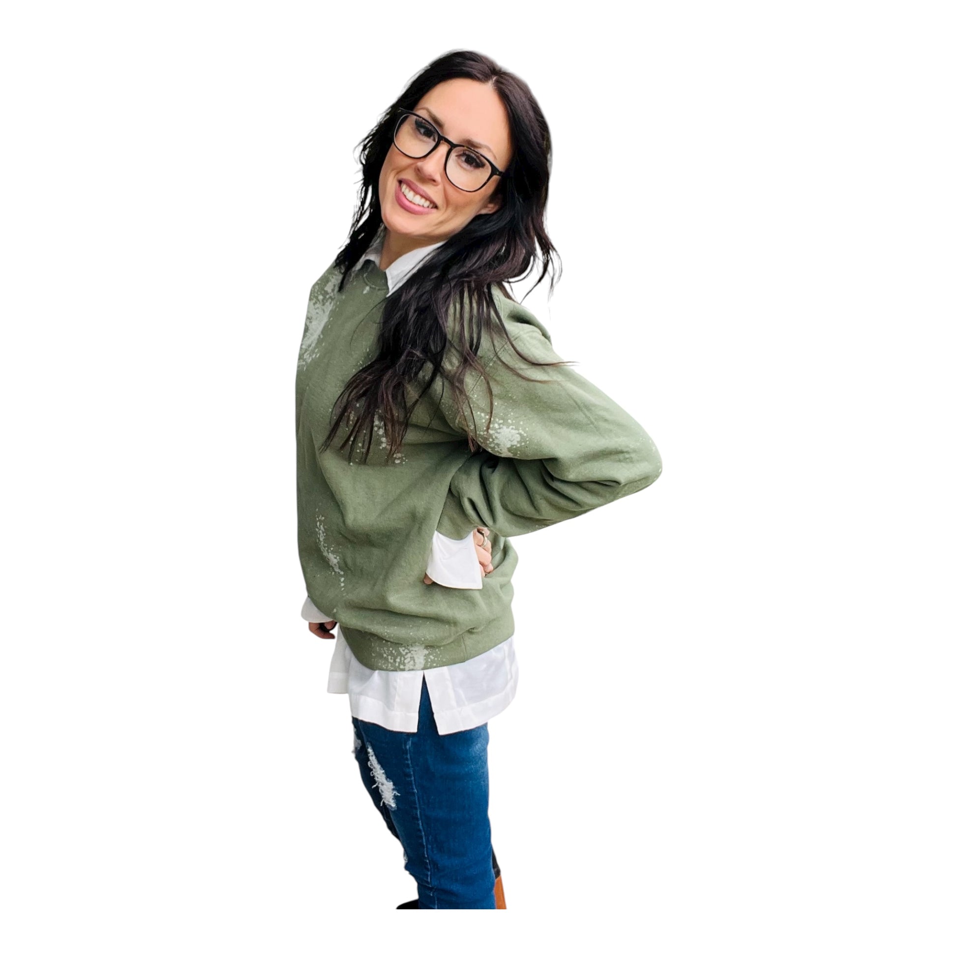 Woman wearing a green sweater over a white shirt with blue jeans on a white background