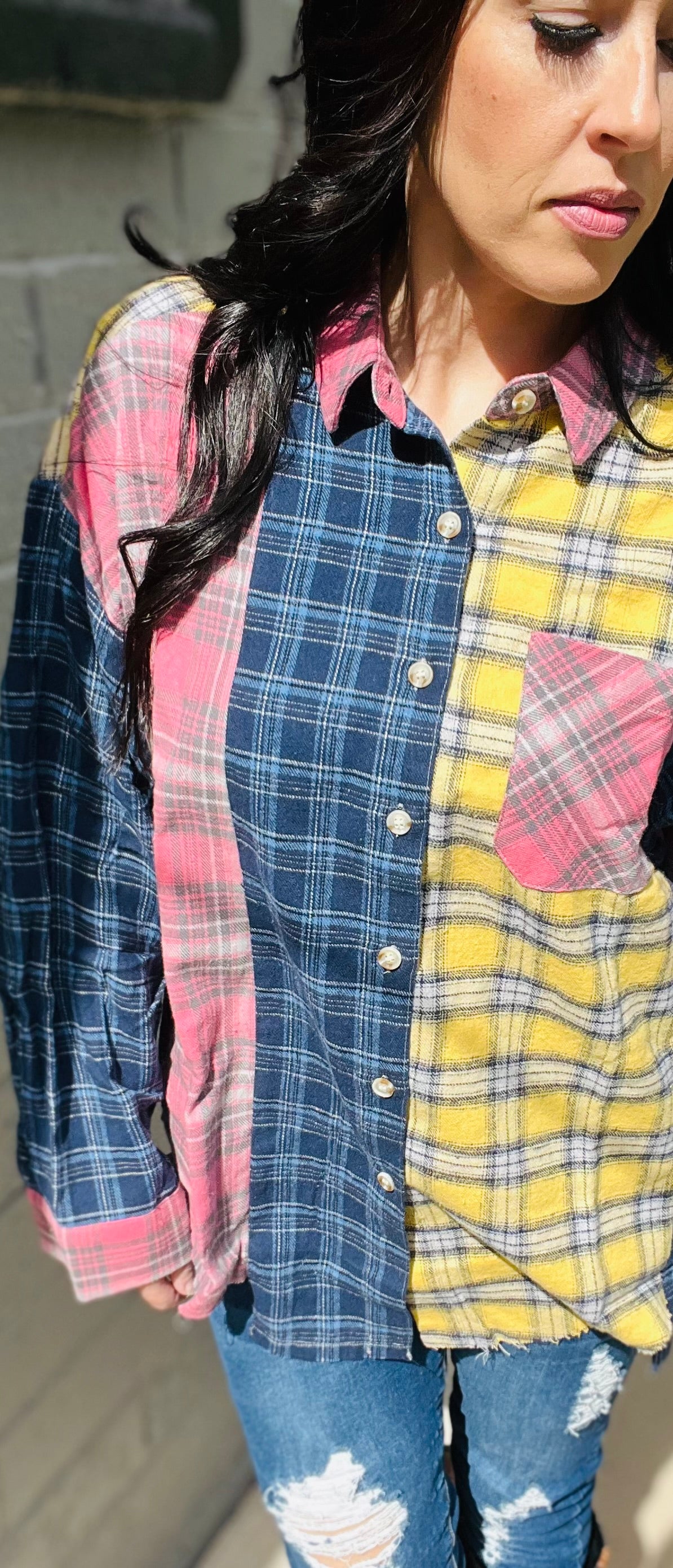 Person wearing a colorful plaid shirt with a blurred background