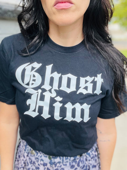 Person wearing a black t-shirt with 'Ghost Him' text outdoors